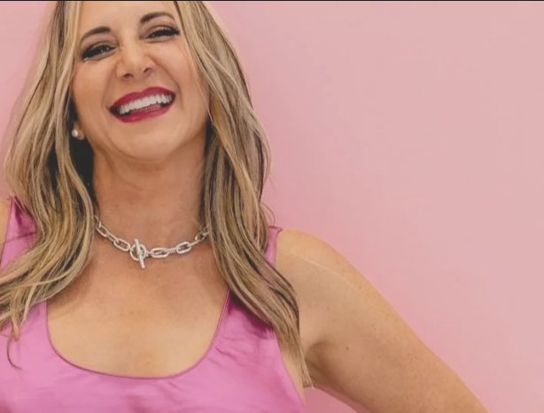 Portrait of Stacey Berger smiling in front of a pink wall